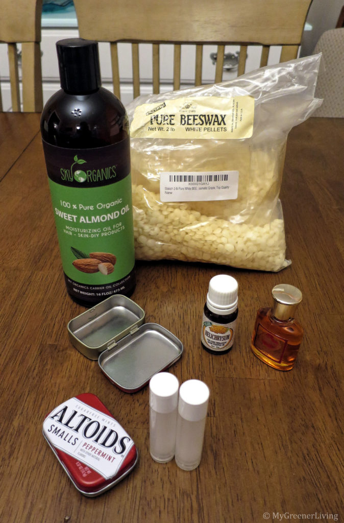 ingredients for making solid perfume: beeswax, almond oil, essential/fragrance oils, and containers: lip balm tubes and small metal tins