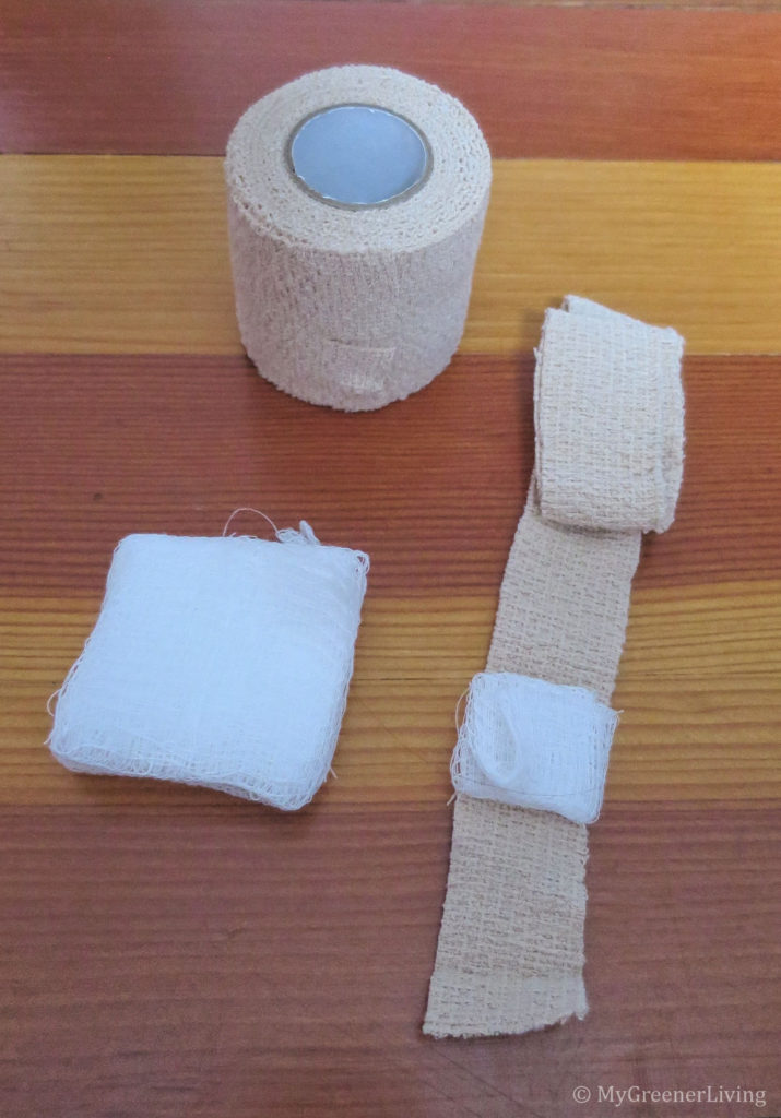roll of self-adhesive bandage, stack of gauze, reusable bandage with gauze pad folded on top